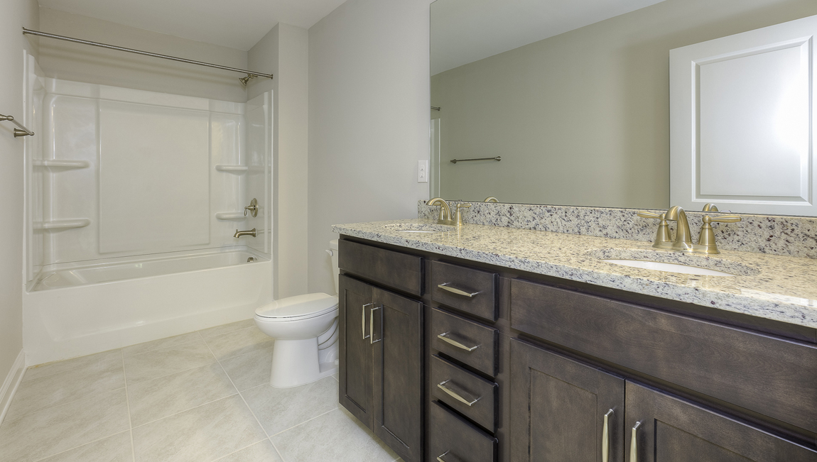 Bathroom with brown cabinets and bathtub