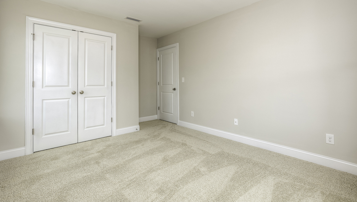 Carpeted bedroom with two large windows