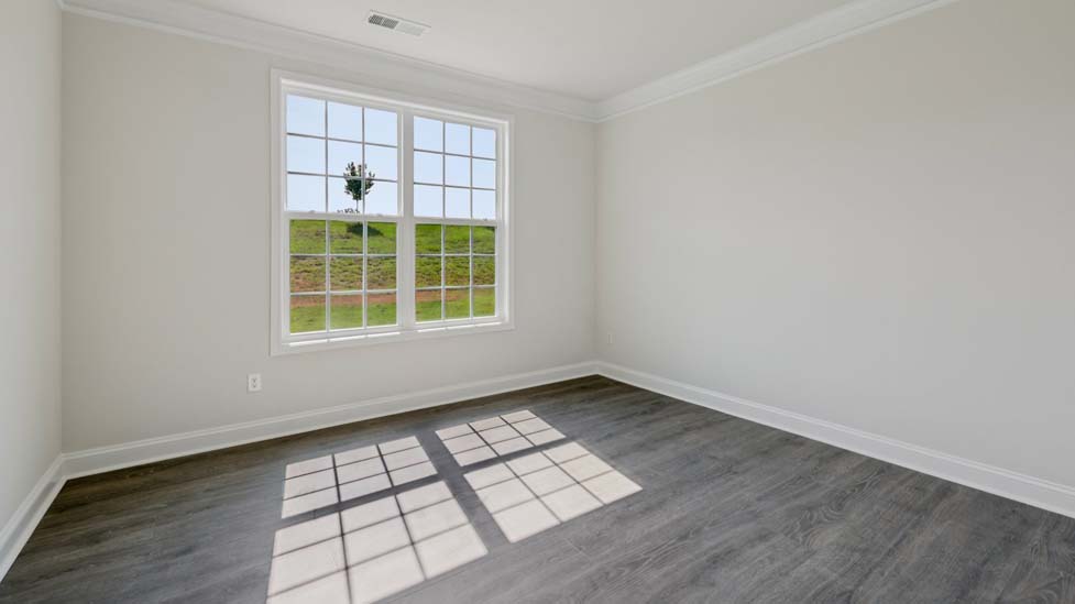 Carpeted guest room with large window and view of closet and entryway doors