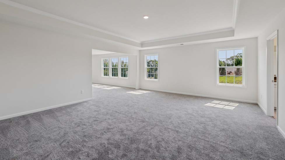 Primary bedroom with carpet and view of entryway double doors