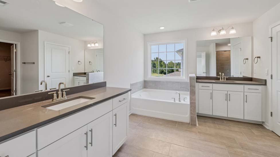Primary bathroom with bathtub and glass door shower combination