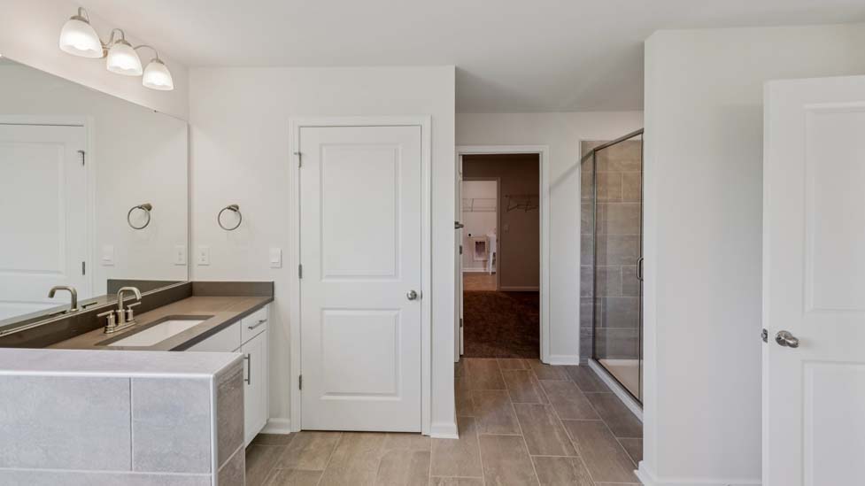 Primary bathroom with bathtub and glass door shower combination