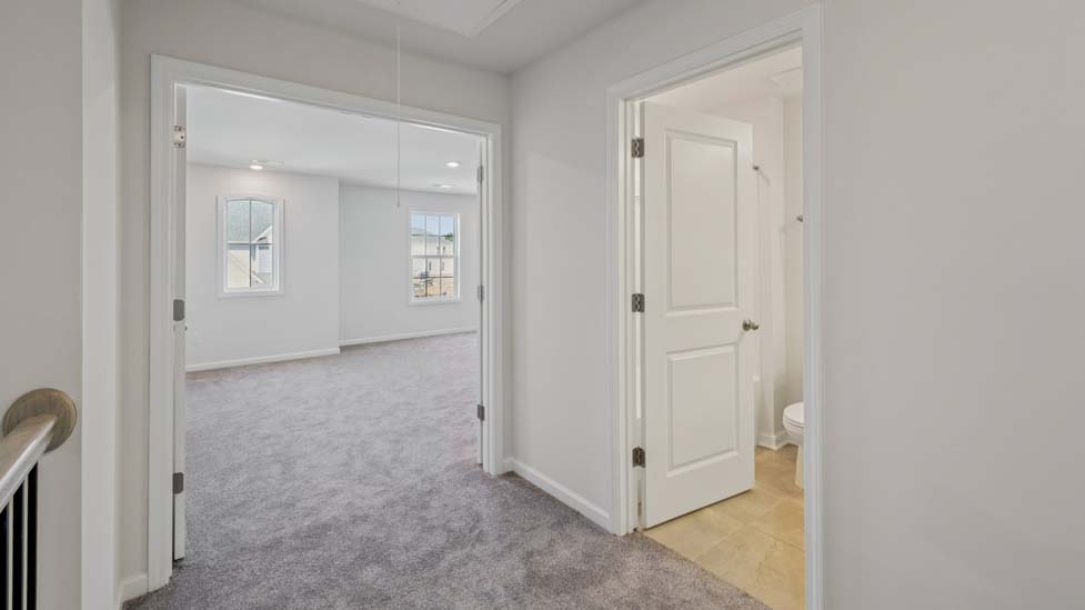 Carpeted bedroom with view of entryway doors and closet
