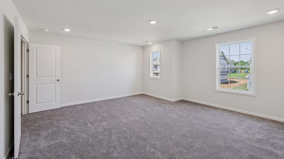 Carpeted bedroom with view of entryway doors and closet