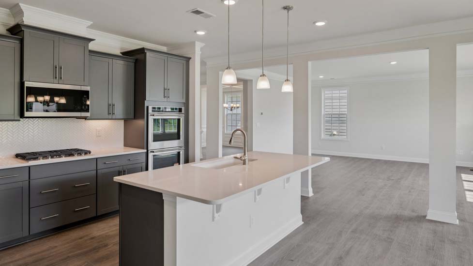 Kitchen and island with white cabinets, subway tile backsplash and stainless steel appliances