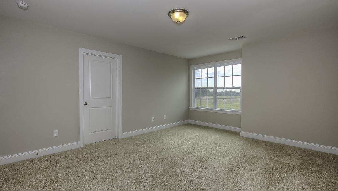 Carpeted bedroom with large window
