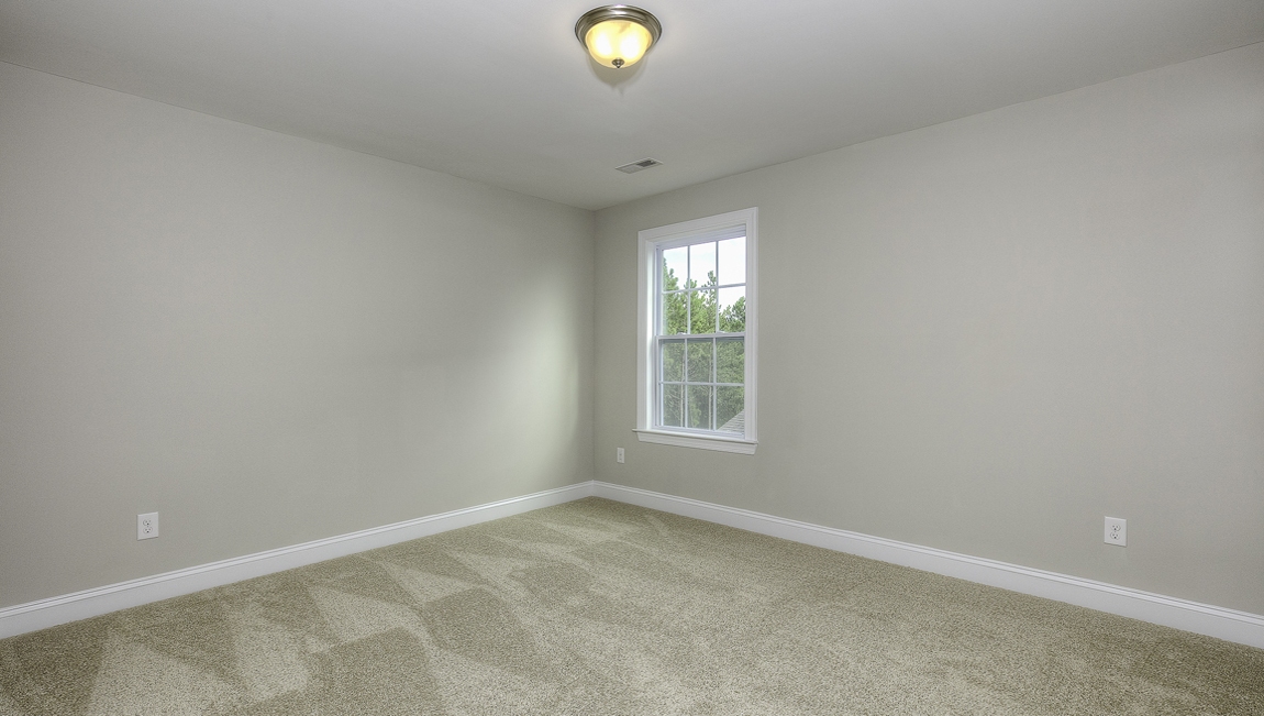 Carpeted bedroom with large window