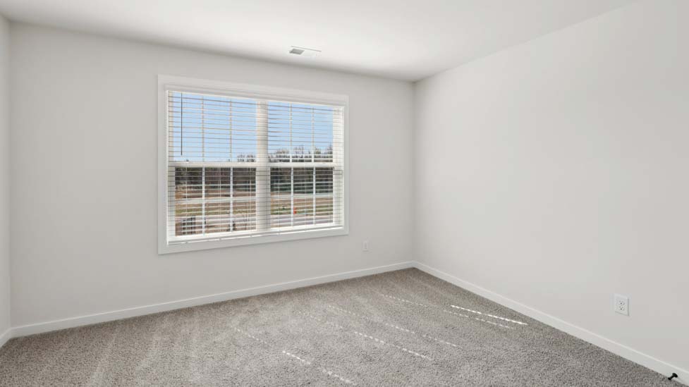 Carpeted bedroom with large window