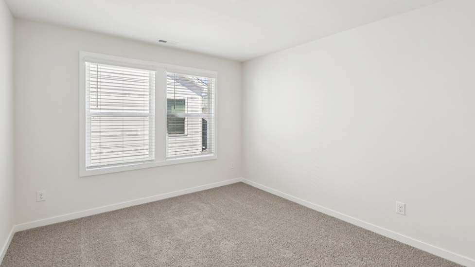 Carpeted bedroom with large window