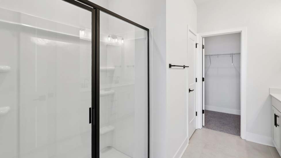 bathroom with standing glass shower and double sinks