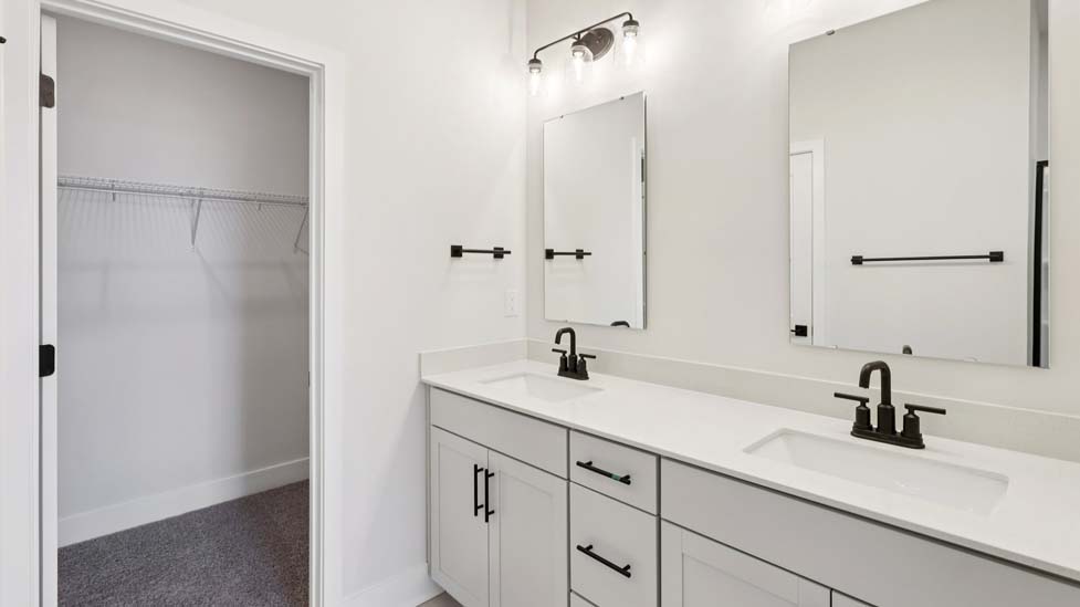 bathroom with standing glass shower and double sinks
