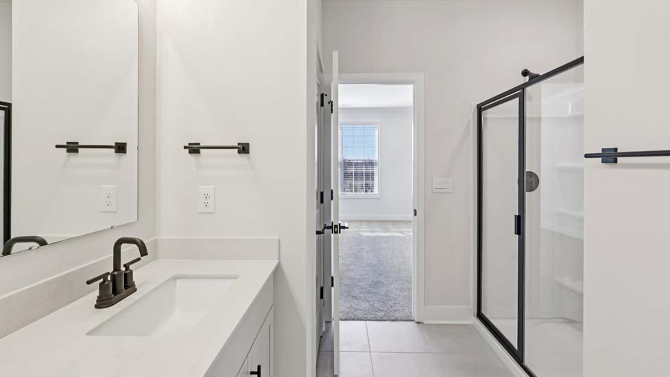 bathroom with standing glass shower and double sinks
