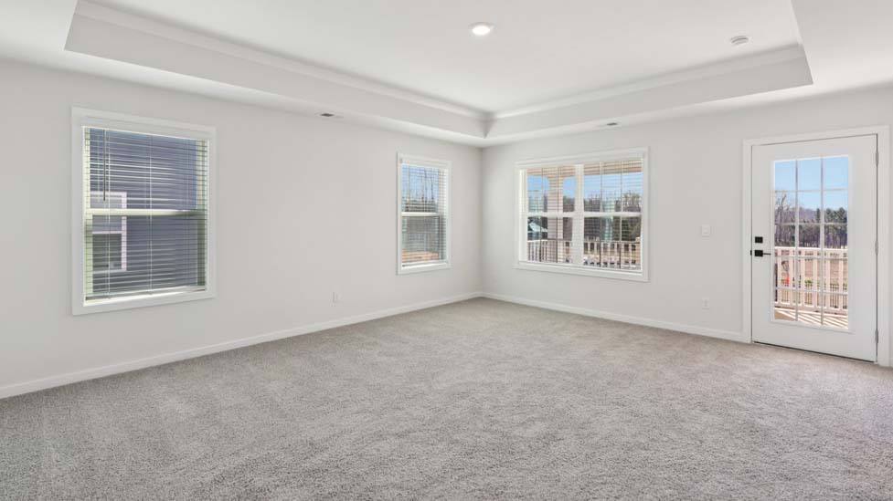 Carpeted primary bedroom with windows