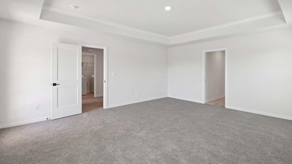 Carpeted primary bedroom with windows