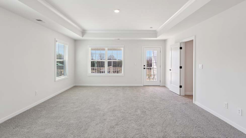 Carpeted primary bedroom with windows