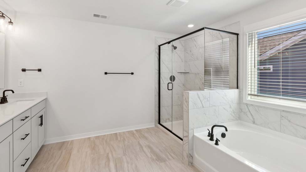 Primary bathroom with standing glass shower and double sinks