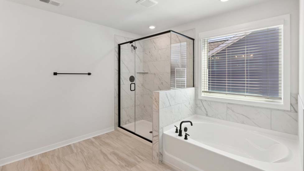 Primary bathroom with standing glass shower and double sinks