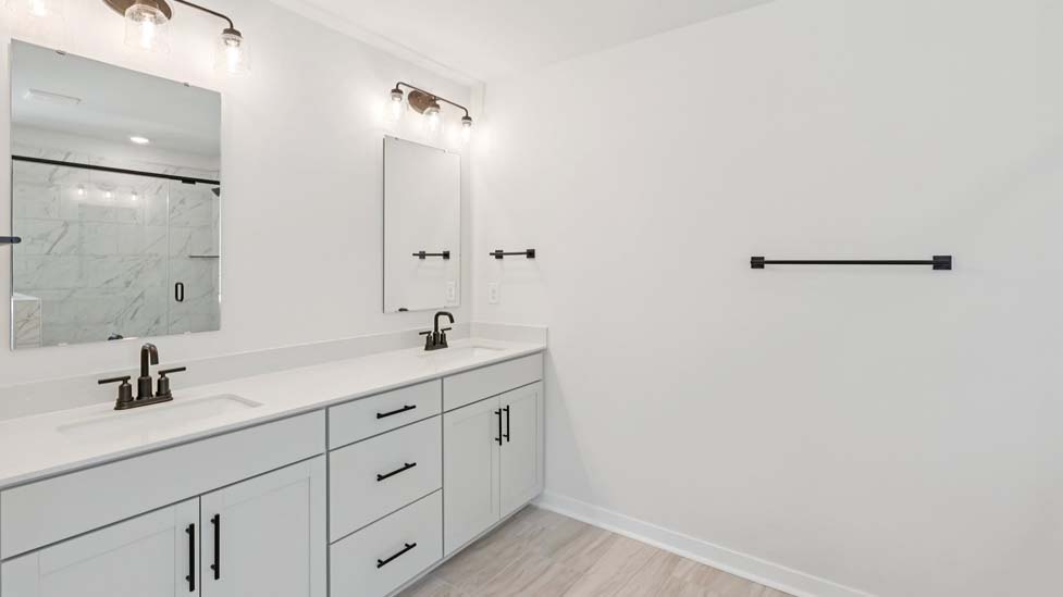 Primary bathroom with standing glass shower and double sinks