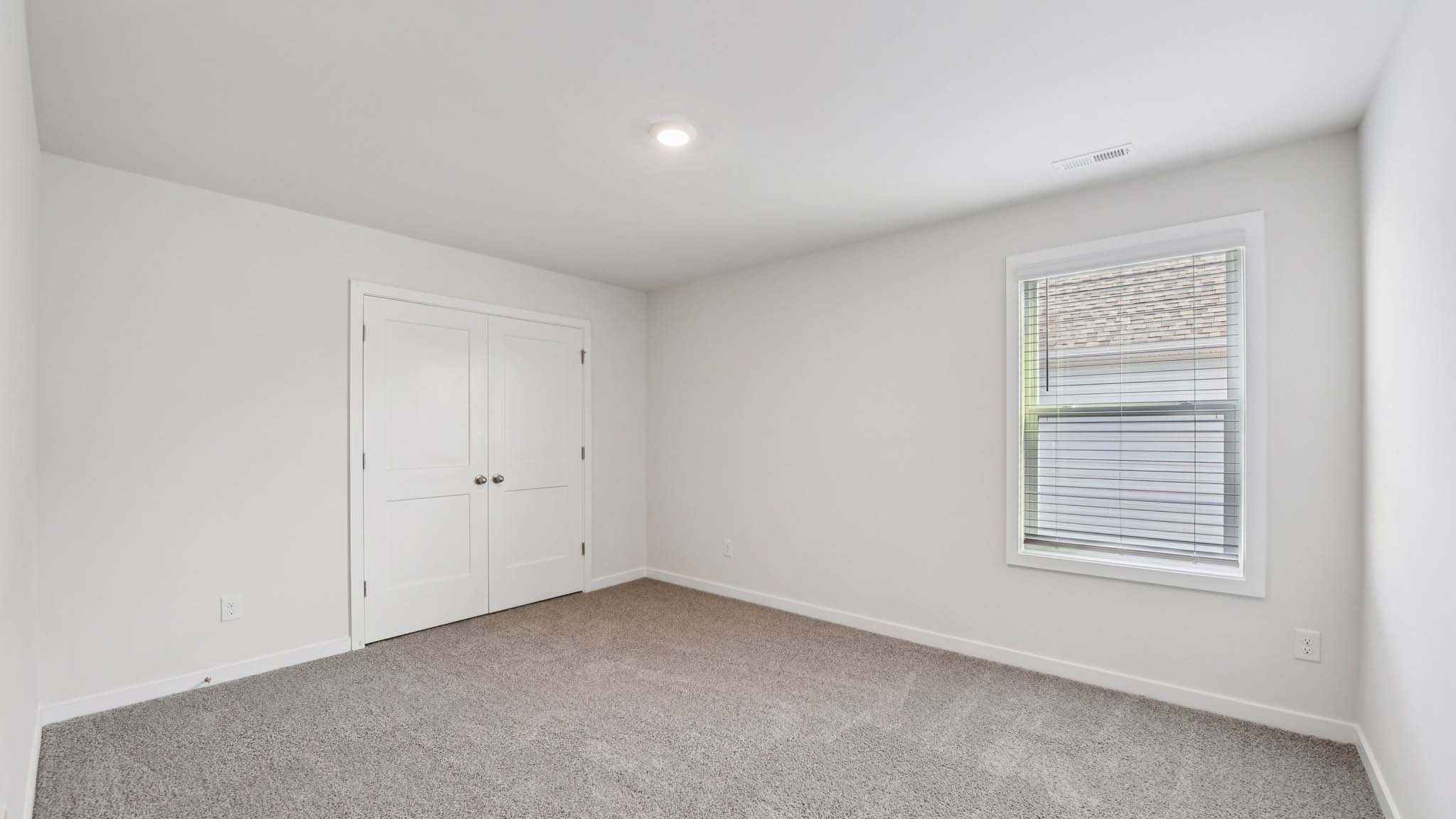 Carpeted bedroom with large window