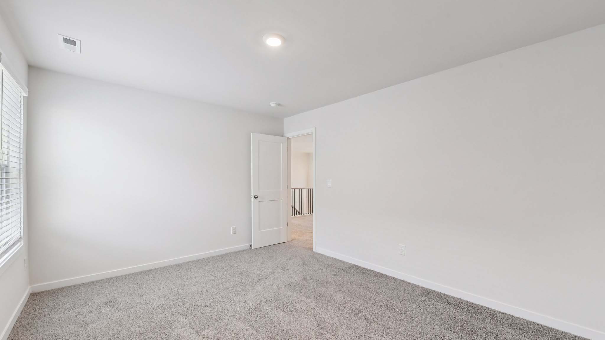 Carpeted bedroom with large window