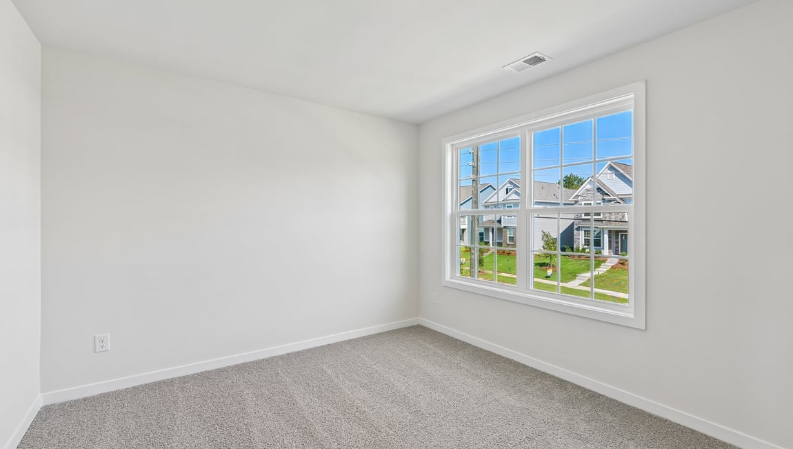 Carpeted bedroom with large window