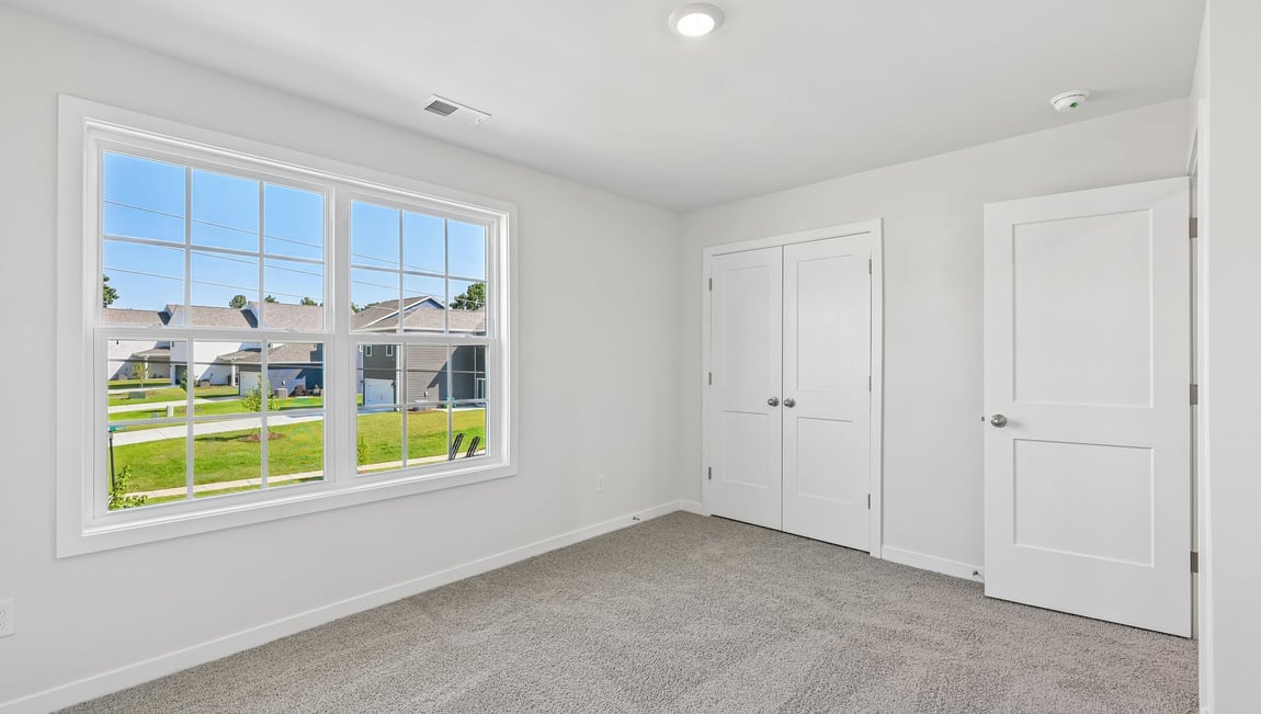 Carpeted bedroom with large window