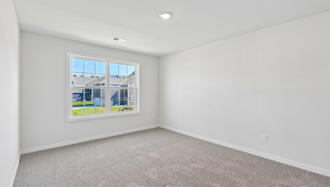 Upstairs carpeted loft area with big windows