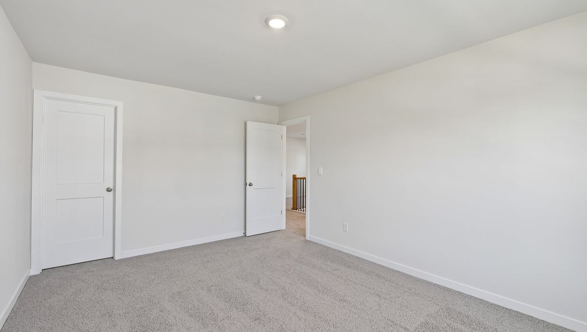 Upstairs carpeted loft area with big windows