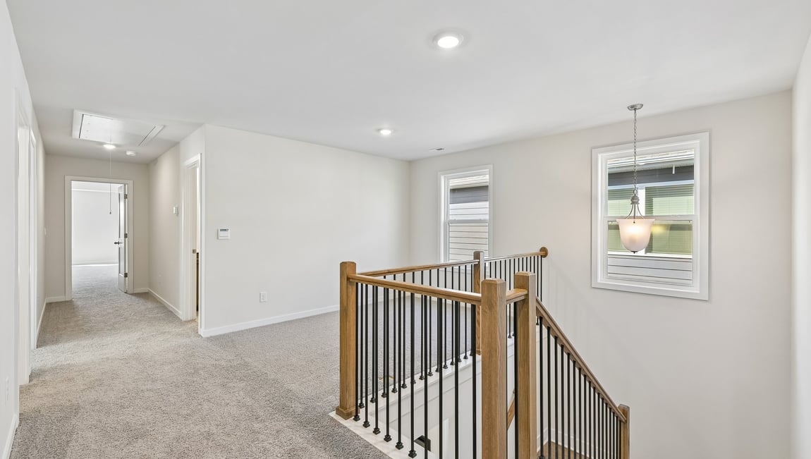 Upstairs carpeted loft area with big windows