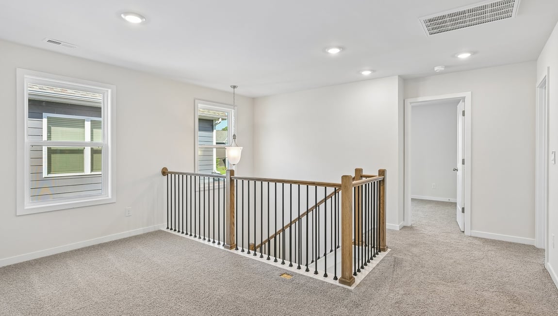 Upstairs carpeted loft area with big windows