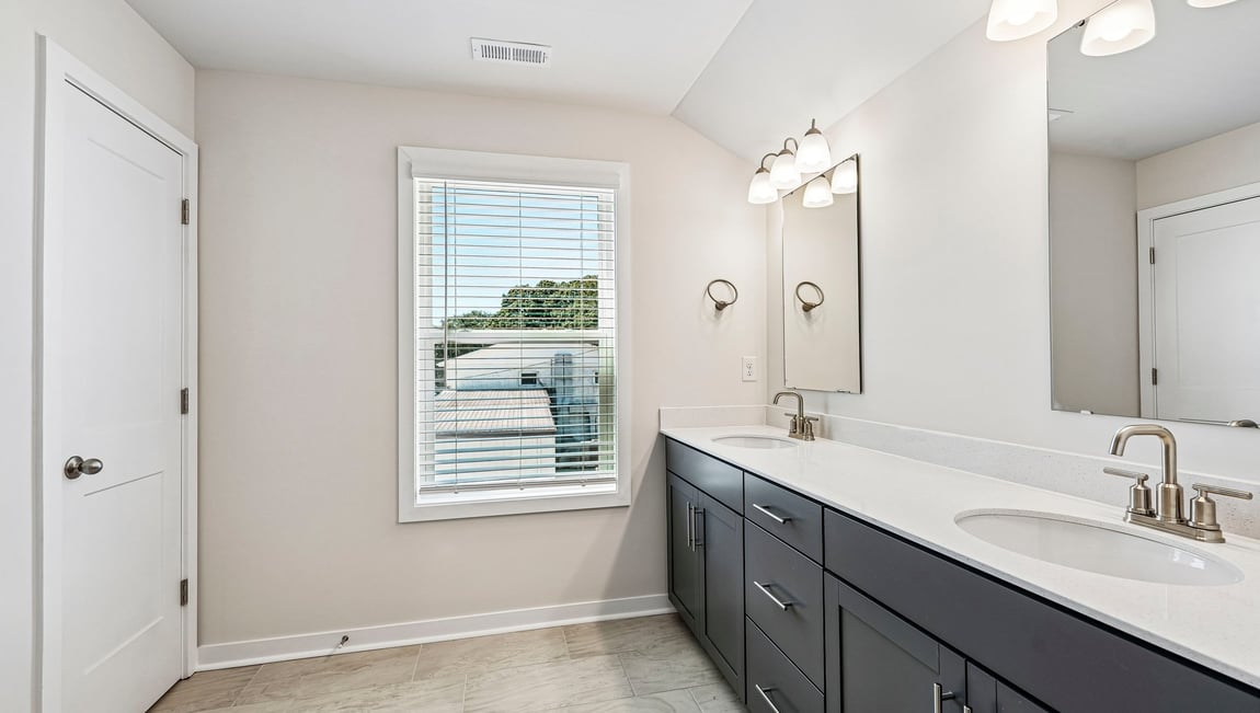 Primary bathroom with double sinks and standing glass shower