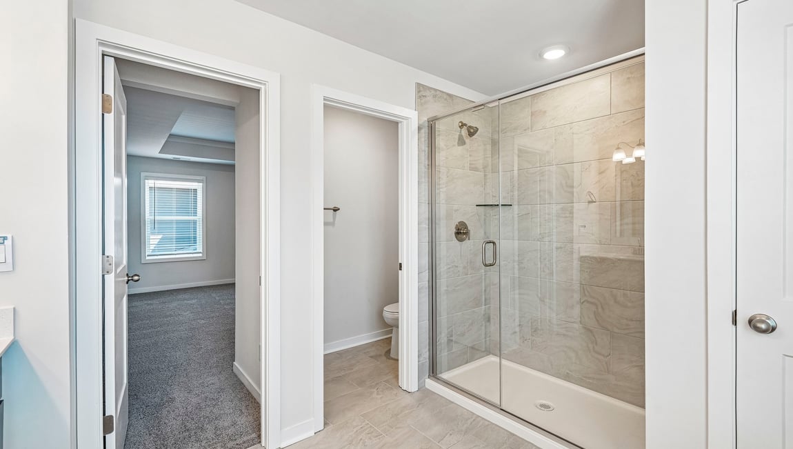 Primary bathroom with double sinks and standing glass shower