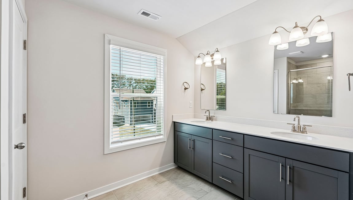 Primary bathroom with double sinks and standing glass shower