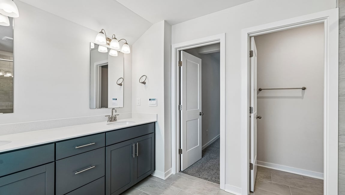 Primary bathroom with double sinks and standing glass shower