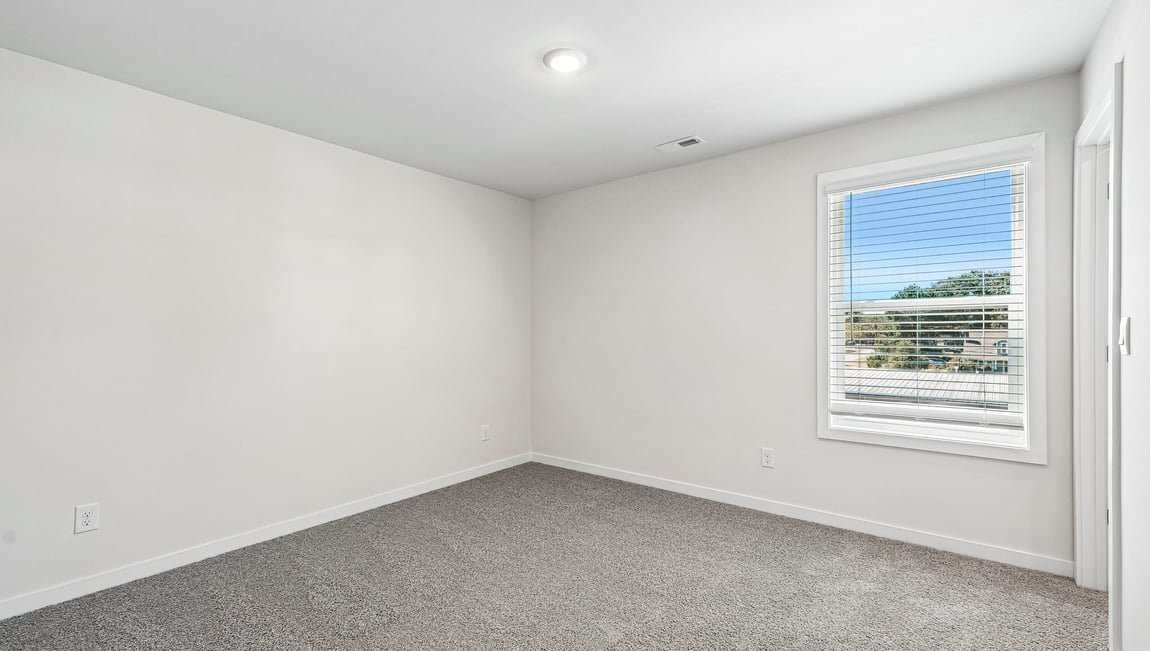Carpeted bedroom with large window