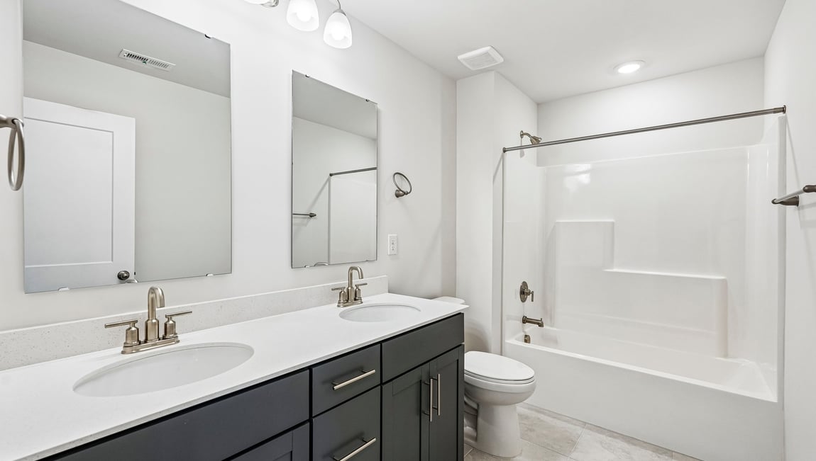 bathroom with double sinks and tub shower