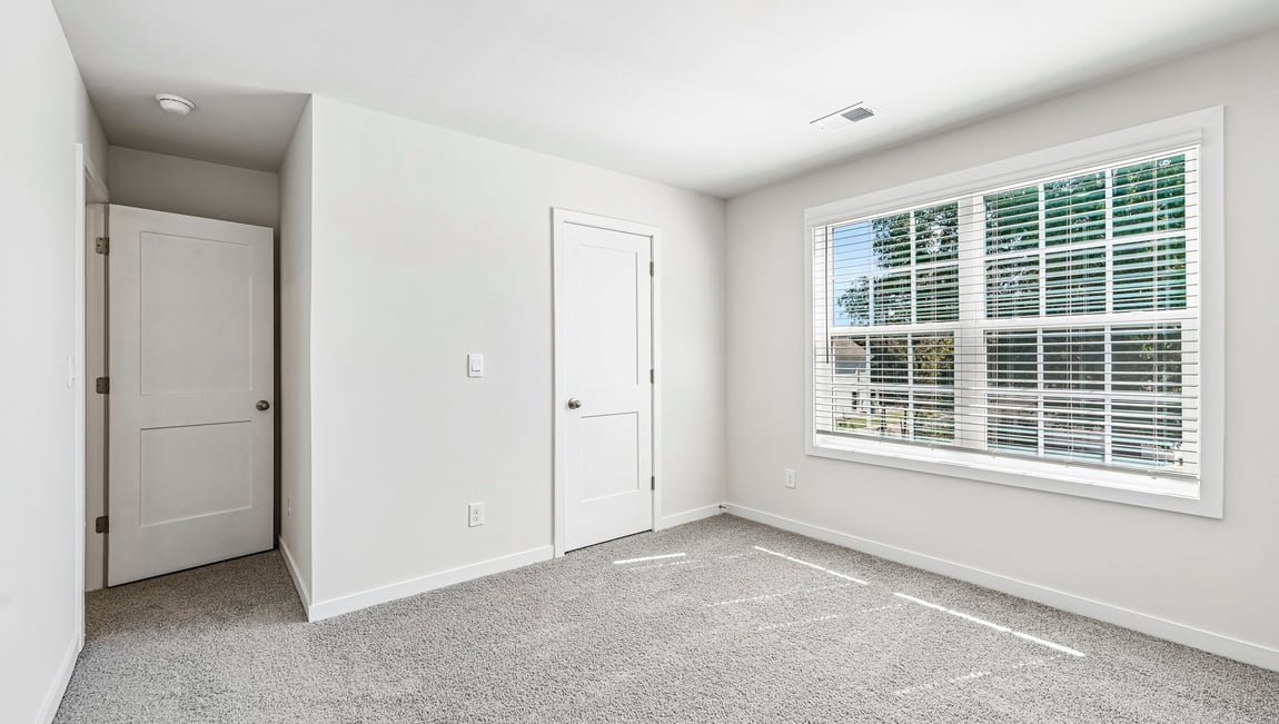 Carpeted bedroom with large window