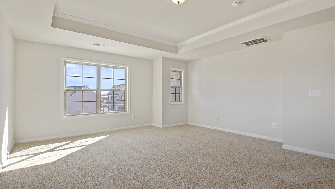 primary bedroom with ceiling fan and large windows