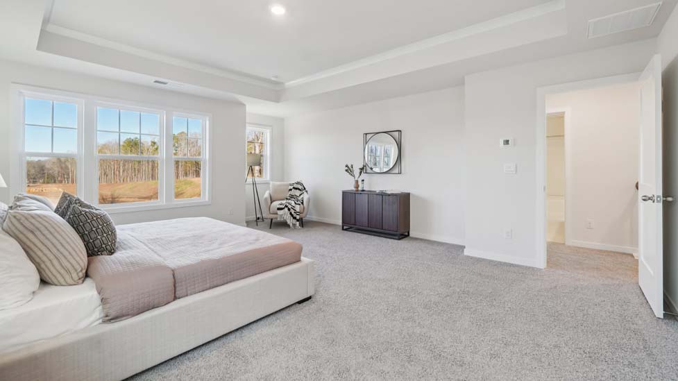 carpeted primary bedroom with large window