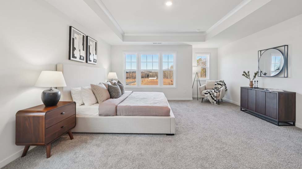 carpeted primary bedroom with large window