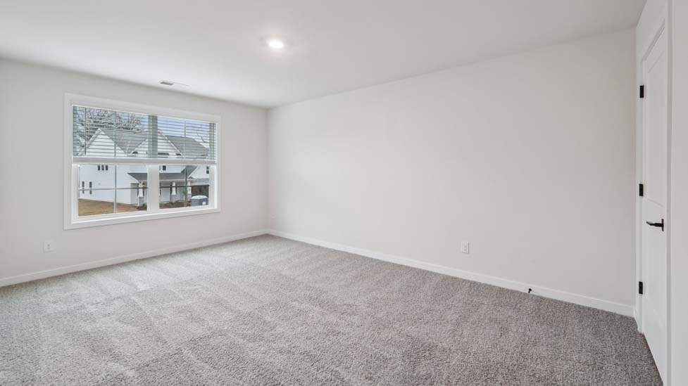 carpeted bedroom with large window