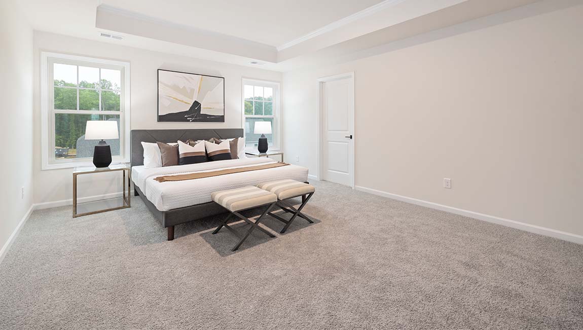 Primary bedroom with carpet and large windows