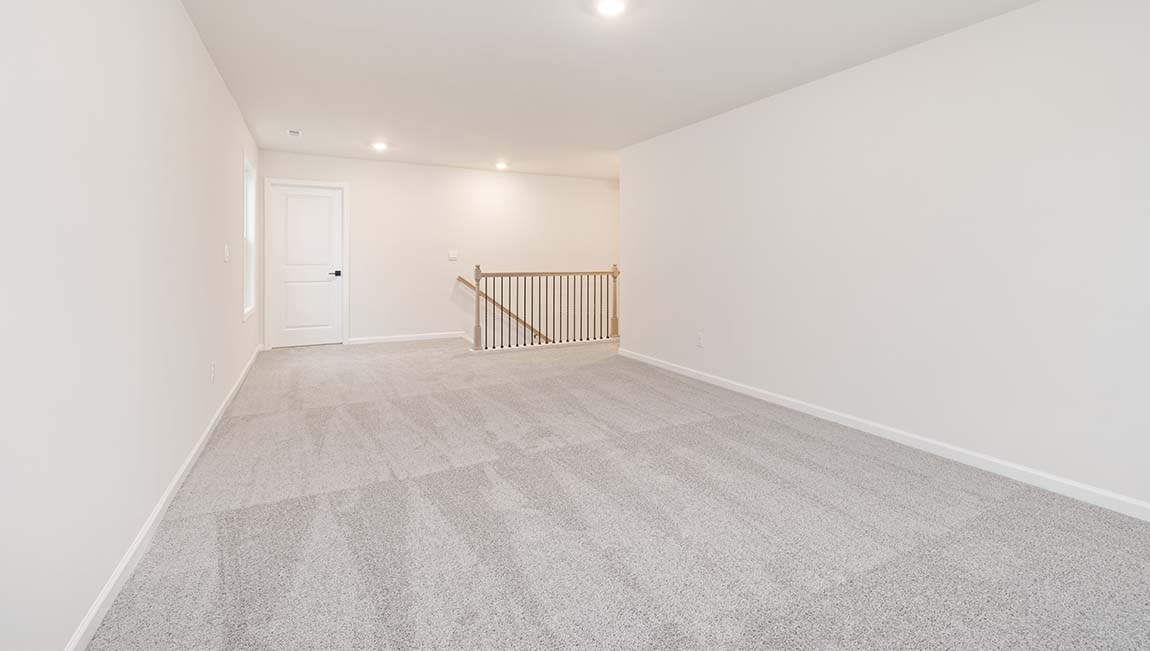 Carpeted upstairs loft with large windows
