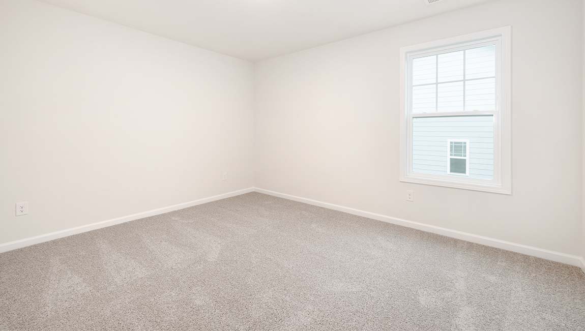 Carpeted bedroom with small window