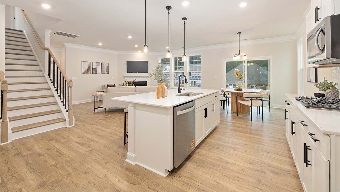 open concept kitchen and island with white cabinets and stainless steel appliances