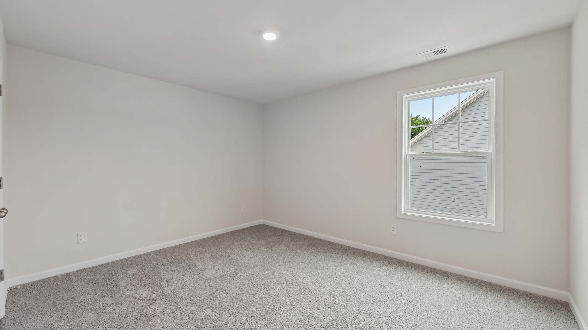 Carpeted bedroom with windows