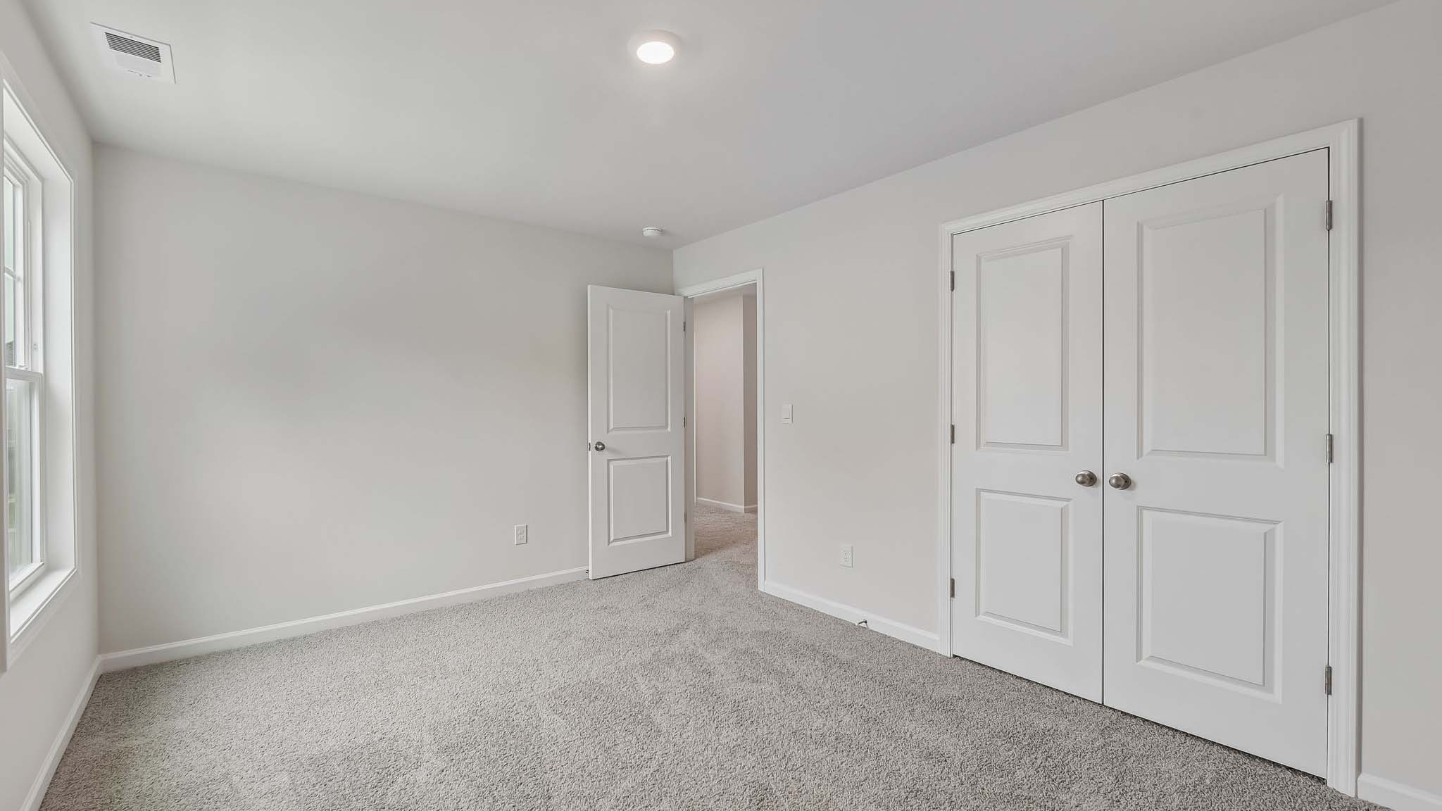 Carpeted bedroom with windows