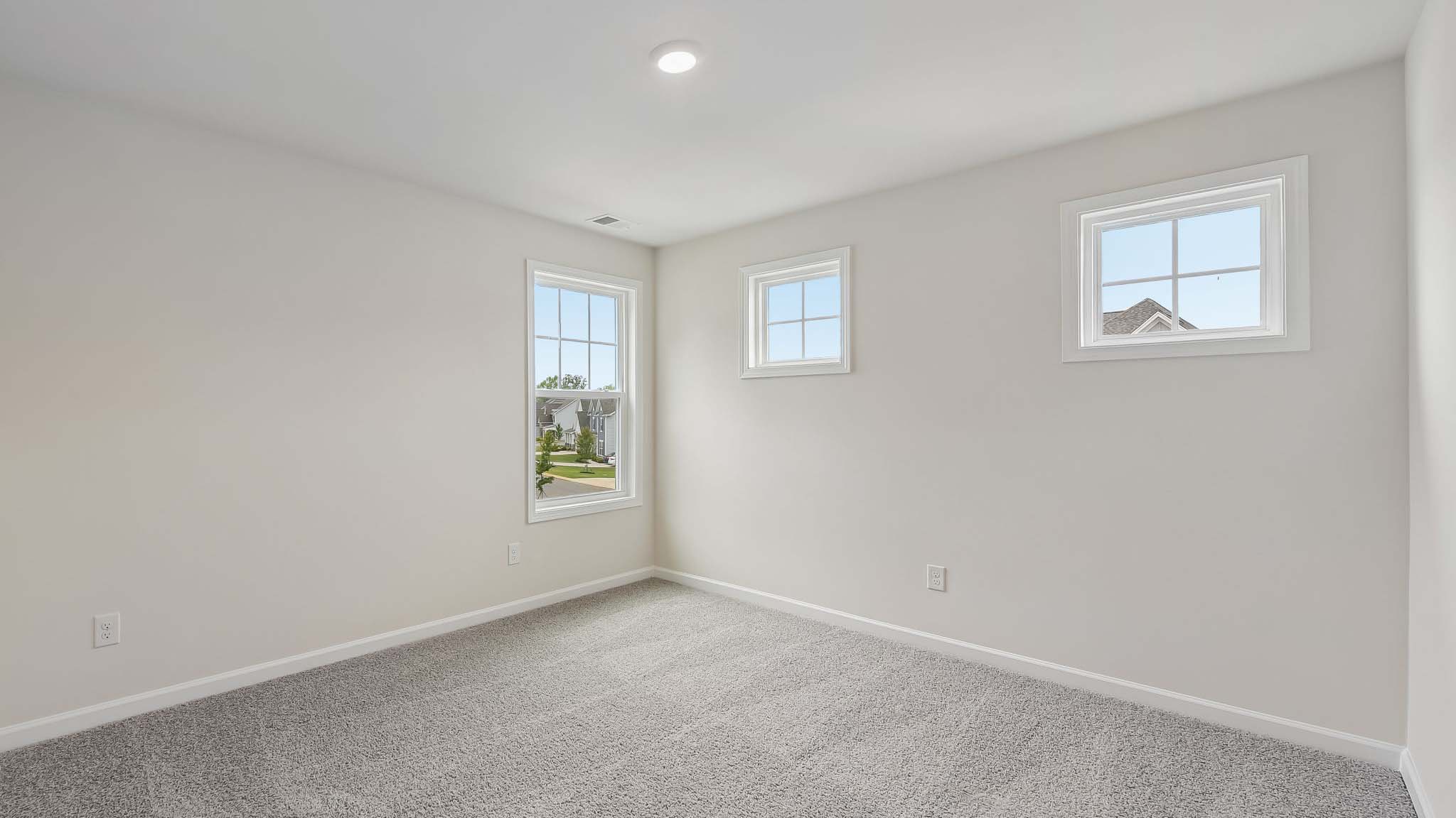 Carpeted bedroom with windows