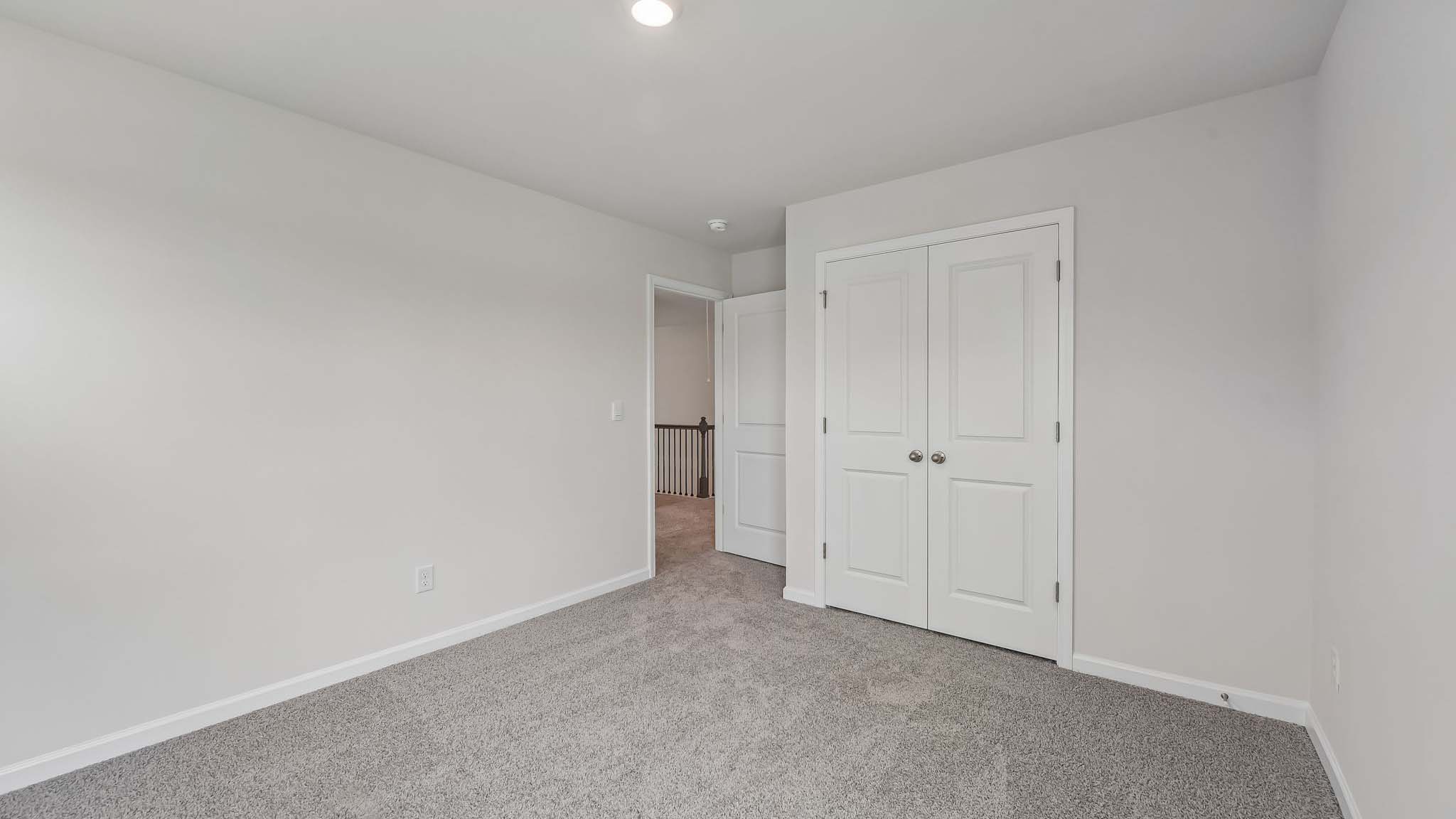 Carpeted bedroom with windows
