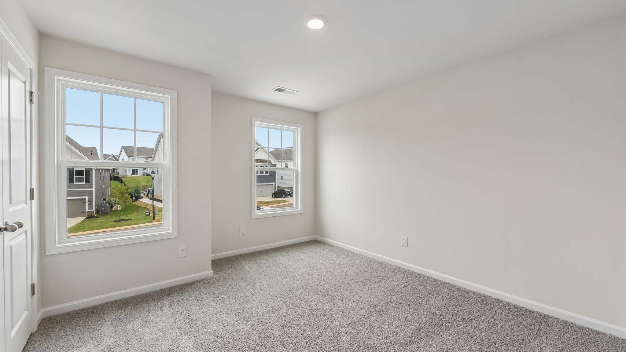 Carpeted bedroom with windows